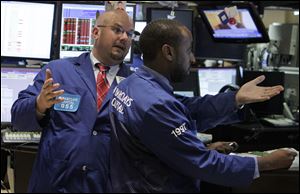 In this Aug. 11, 2010 photo, specialist John Urbanowicz, left, talks with a colleague on the floor of the New York Stock Exchange. Stocks are opening Wednesday, May 22, 2013, slightly higher as investors watch for the latest moves from the Federal Reserve.  (AP Photo/Richard Drew)