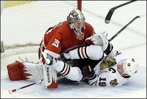 Chicago Blackhawks center Jonathan Toews crashes into Detroit goalie Jimmy Howard during the second period. Howard kept everything out of the night on Thursday night to give the Wings a commanding lead as the series heads back to Chicago.