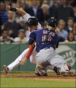 Boston Red Sox' Jacoby Ellsbury, left, reaches down towards home plate as he is tagged out by Cleveland Indians catcher Yan Gomes on a single by Dustin Pedroia during the third inning of a baseball game at Fenway Park in Boston, Thursday, May 23, 2013. (AP Photo/Charles Krupa)