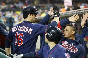 Minnesota Twins' Josh Willingham (16) is congratulated in the dugout after his three-run home run off Detroit Tigers starting pitcher Rick Porcello during the third inning of a baseball game in Detroit, Thursday, May 23, 2013. (AP Photo/Carlos Osorio)