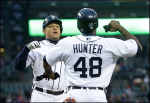 Detroit Tigers' Miguel Cabrera is congratulated by teammate Torii Hunter after hitting a two-run home run during the first inning of a baseball game against the Minnesota Twins in Detroit, Thursday, May 23, 2013. (AP Photo/Carlos Osorio)