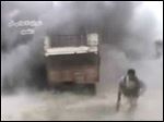  AP10ThingsToSee - In this image from amateur video obtained by a group called Ugarit News, a rebel runs from an explosion, Sunday, May 19, 2013 in Qusair, Syria. An intense battle drove rebels from large parts of Qusair, part of a withering government offensive aimed at securing a strategic land corridor from Damascus to the Mediterranean coast. (AP Photo)