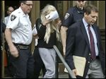  Actress Amanda Bynes, center, wearing sweats and a blonde wig, shields her face as she is escorted after a Manhattan criminal court appearance.