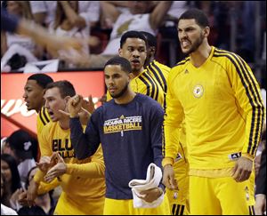Indiana Pacers players cheer, from the bench, their team during the second half.