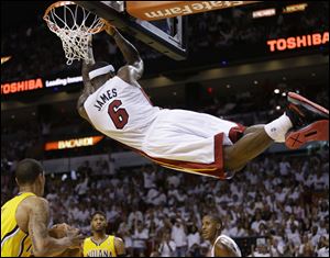 Miami Heat forward LeBron James (6) hangs from the basket after dunking the ball during the second half.