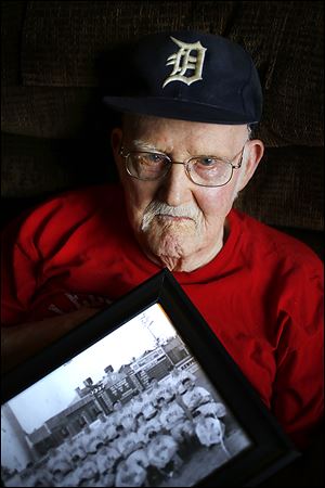 Ken Silverthorne, 93, holds a Mud Hens team photo from the 1930s, one of his prized possessions.
