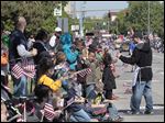  U.S. flags are distributed along the Memorial Day parade route on Jackson Avenue. A later service organized by the Toledo-Lucas County Memorial Day Association brought many somber moments.