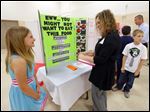  Hailey Blackford, 10, describes her science project to Laura Sauber, treasurer and CFO of the Sylvania School District.
