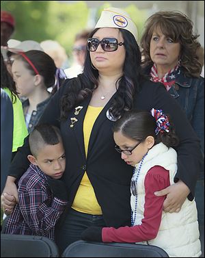 Veronica Mora, a Gold Star Wife, holds her son, Topher, 7, and daughter Celina, 9, at Toledo’s Memorial Day ceremony that followed Saturday’s parade.