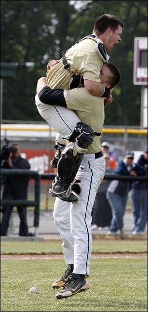 Perryburg pitcher Mark Delas (19), right, hugs catcher Kyle Durham (21) after defeating Norwalk in the Division I district baseball final at Carter Park in Bowling Green, Ohio. 