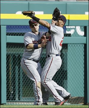 The Twins’ Wilkin Ramirez, right, and Josh Willingham collide after chasing a fly ball hit by the Tigers' Omar Infante in the sixth inning. Ramirez was injured on the play, but hung on to make the out.