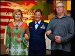  Teresa Fedor, left, and Jeff Lever, right, escort Air Force veteran Jen Bauer as she is announced at the Dancing with the Military Stars event.