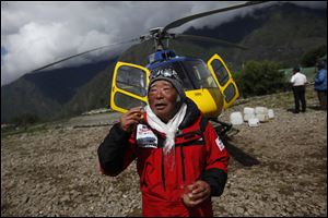 Japanese climber Yuichiro Miura, 80, who became the oldest conqueror of Mount Everest on Thursday, gestures at Lukla airport where he takes a break while returning from Camp 2 to Katmandu by helicopter at Lukla, Nepal, today.