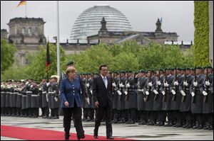 German Chancellor Angela Merkel, left, welcomes the Prime Minister of China  Li Keqiang  for a meeting at the chancellery Sunday in Berlin.