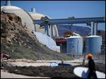  Surfers walk along a beach nearby the San Onofre Nuclear Power Plant in San Onofre, Calif. 