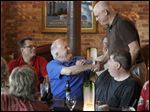  Peter Cavanaugh, center, greets Mark Benson during a dinner and reunion of local radio broad-casters at Manhattan’s Restaurant in the Uptown district. Mr. Cavanaugh, a member of the Rock and Roll Hall of Fame and former Toledo radio broadcasting exec, put together the reunion.