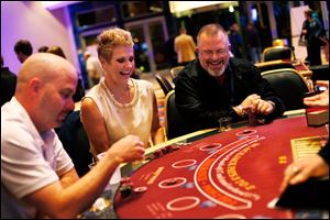 Temperance, Mich. residents Chris and Paul Szymanski, center and right, smile as they play blackjack along with Chicago, Ill. resident Shane Engels.