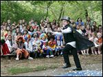  Christopher Laux, the master of ceremonies, introduces an act in front of the audience during  an end of the year circus in the outdoor amphitheater at Stranahan Elementary School.