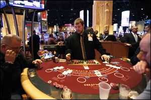 Bedford, Mich. resident Greg Stockard deals cards at a blackjack table during the Hollywood Casino one year anniversary celebration Friday.