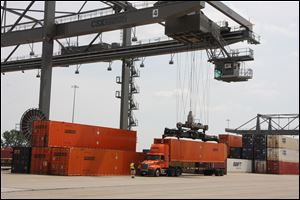 A crane at the CSX Northwest Ohio Terminal in North Baltimore lowers a freight container onto a truck chassis.