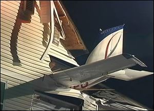 In this frame grab from video provided by NBC4 Washington, the tail section of a small plane sticks out from the side of an apartment building after crashing into the complex early today in Herndon, Va. 