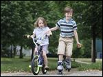  Siblings Wren Rausch, 8, right, and Lucy Rausch, 6, left, race down the sidewalk in front of their house on Princeton Dr. while playing outside on May 22, 2013.