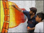  Ricardo Quinonez Aleman and Juan Ferime, 10, of Adrian, work on the mural at the Providence Center. The Organization of Latino Artists sponsored the project. 