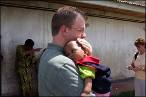 Bryan, Ohio resident Mark Holbrook holds the young African boy he and his wife plan to adopt later this year.