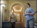  Employees Susan Roberts-McGlade, left, and Angela Metcalf, right, talk about the house during a tour. Originally known as Stranleigh Manor, the mansion was once the estate of Page and Robert Stranahan.
