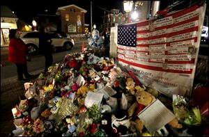 A U.S. flag displays the name of 26 victims killed at Sandy Hook Elementary School stands at a makeshift memorial in the Sandy Hook village of Newtown, Conn., in December.