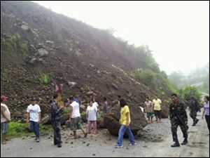 Rresidents look at boulders that partially blocked a highway after an earthquake in North Cotabato in southern Philippines Sunday.