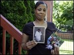  Breast cancer survivor Alicia Cook holds photos of family members who have also been afflicted by breast cancer, outside her home in Chicago. 
