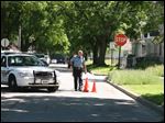  A Toledo Police Officer marks shell casings with cones at the corner of Moore and Elm streets in North Toledo.