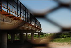 The Tornillo-Guadalupe border bridge is seen through a fence in Tornillo, Texas. The bi-national project is nearly finished in the U.S. side, while work has not started on the Mexican side of the river.