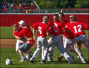 Jakob Letson, left, is congratulated after his game-winning hit as Bedford celebrates a win over Saline in a Division 1 district final.