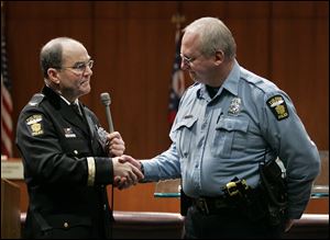 Officer Robert Adams, right, is presented with badge No. 1 by then Toledo Police Chief Mike Navarre during a Toledo police department promotions ceremony in February, 2010.