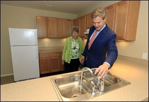 Tom Seeman and his mother, Virginia Seeman of Sylvania, view an apartment during a dedication ceremony and open house for the new Collingwood Green Senior Community.