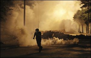A protester runs to avoid tear gas during clashes with the police in Istanbul early today.