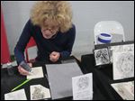  Ottawa Hills artist Barbara Goodman, owner of Ceramigraphix and an art instructor at Owens Community  College, works on a hand-stippled, custom tile at the Toledo Kennel Club Dog Show.  