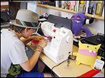  Ray Tollison looks over the shoulder of his son Sam as he works on a drawing of a monster doll at their home in Fort Collins, Colo. The Tollisons launched A Monster to Love 18 months ago.