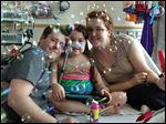  Sarah Murnaghan, center, celebrates the 100th day of her stay in Children's Hospital of Philadelphia Friday, May 30, with her father, Fran, left, and mother, Janet.