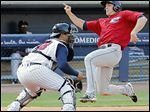  Columbus’ Matt Lawson runs past Toledo catcher Ramon Cabrera to score during the first inning. The Mud Hens rallied to win.