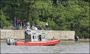 A Coast Guard boat cruises slowly up the Maumee River as Toledo Fire Department divers search for the missing girl Thursday.