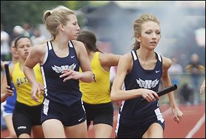 Napoleon’s Sarah Waisner, right, takes the baton from Alexa Sonnenberg during the state championship meet Friday at Jesse Owens Memorial Stadium in Columbus, Ohio.