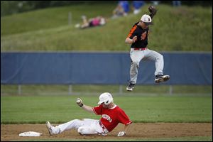 Bedford senior Jonathan Shepherd slides safely into second as Belleville junior Anthony Kovach jumps to catch a throw. Shepherd scored the team's single run in the 1-0 win.