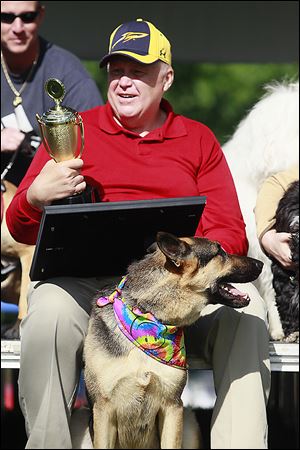 Bob Reinbolt of Toledo holds the winner's trophy on behalf of Katie, his German shepherd, who won the The Blade's 8th Annual Pet Idol contest. 