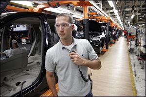 Jeff Caldwell, 29, a chassis assembly line supervisor, monitors the assembly line at the Chrysler Jefferson North Assembly plant in Detroit. The auto industry is on a hiring spree as car makers and parts suppliers race to find engineers, technicians and factory workers to build the next generation of vehicles.