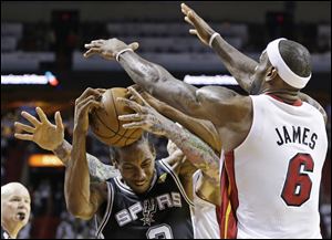 San Antonio's Kawhi Leonard is stopped by Miami's LeBron James, who had 17 points, eight rebounds, and seven assists in Sunday night's Game 2 of the NBA Finals.
