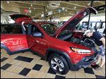  Darryl Bauman Jr., of Whitehouse, looks at a 2014 Jeep Cherokee Trailhawk at Charlie's Dodge in Maumee Saturday.