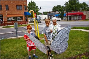 Molly Wachtmann of Whitehouse and her grandsons Luke Yokum, 9, left, and Matthew, 12, center, inspect a newly erected fiberglass butterfly in Whitehouse. The trio examined each butterfly in town.